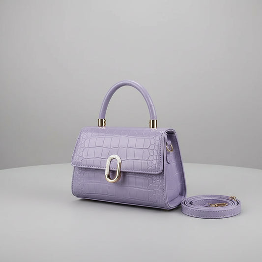 Purple handbag with gold accents held by a person against a neutral background